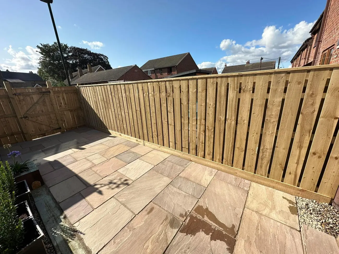 New Yorkshire board fence above an Indian stone patio in the evening sun