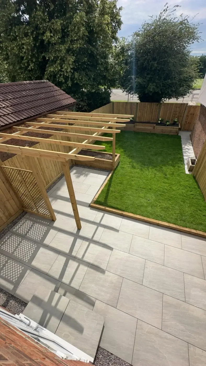 Porcelain patio with a timber pergola and lattice screen beside a lawn edged with sleepers