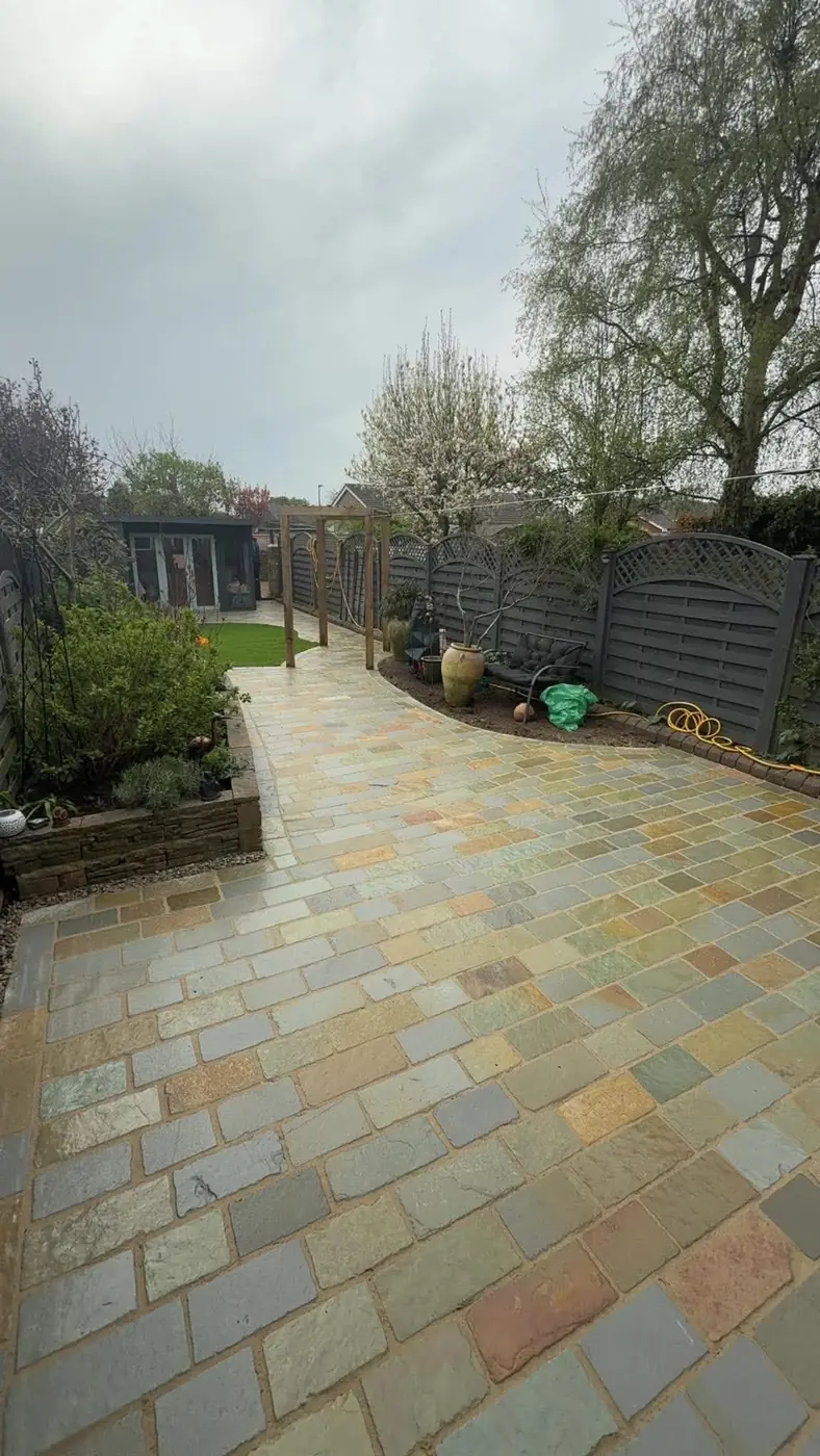Winding Indian stone setts path leading to a pergola arch and a garden room