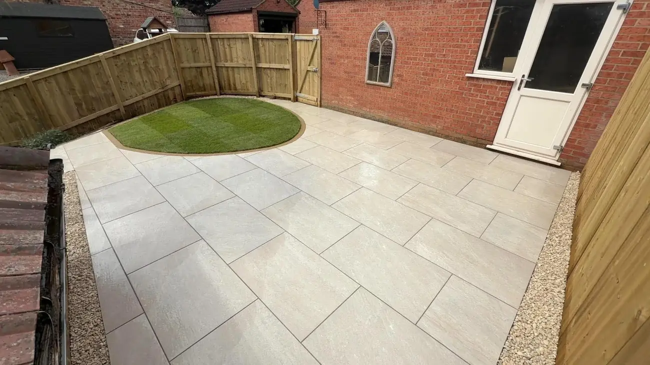 Cream porcelain patio with a round lawn and gravel edging